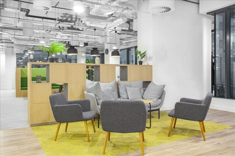 Lounge area with grey chairs and a yellow rug.