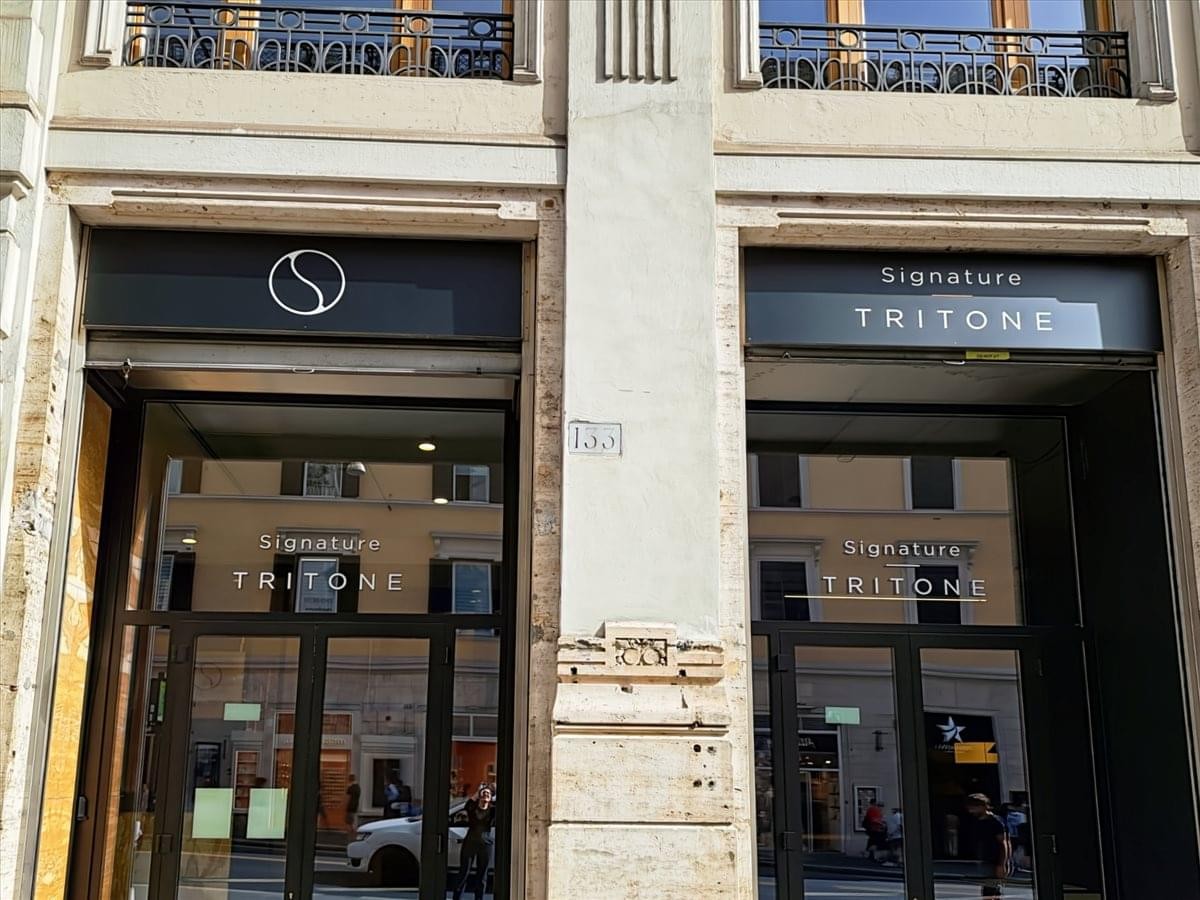 Grand exterior entrance of 132 Via Del Tritone with traditional stone facade and signature signage.