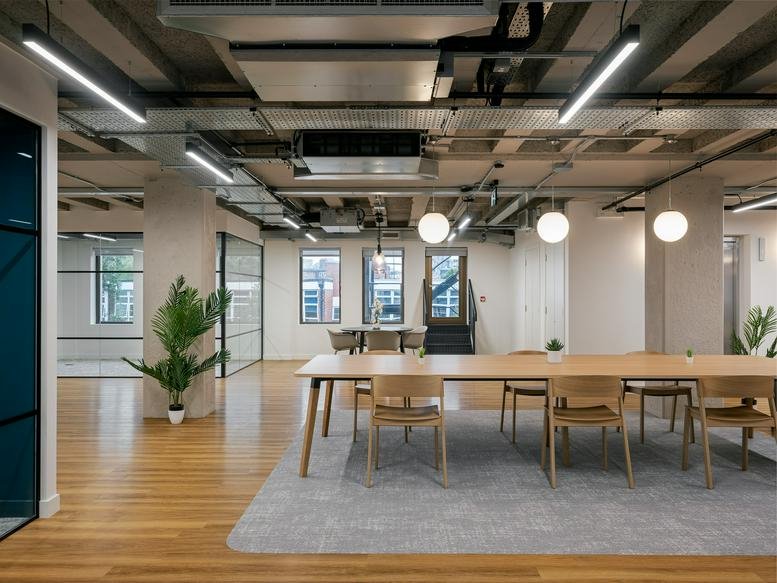 Spacious communal dining area at Maya House, 134-138 Borough High Street with a long wooden table and plants.
