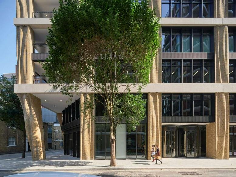 Exterior view of the contemporary facade at 135 Park Street London with tree-lined entrance.
