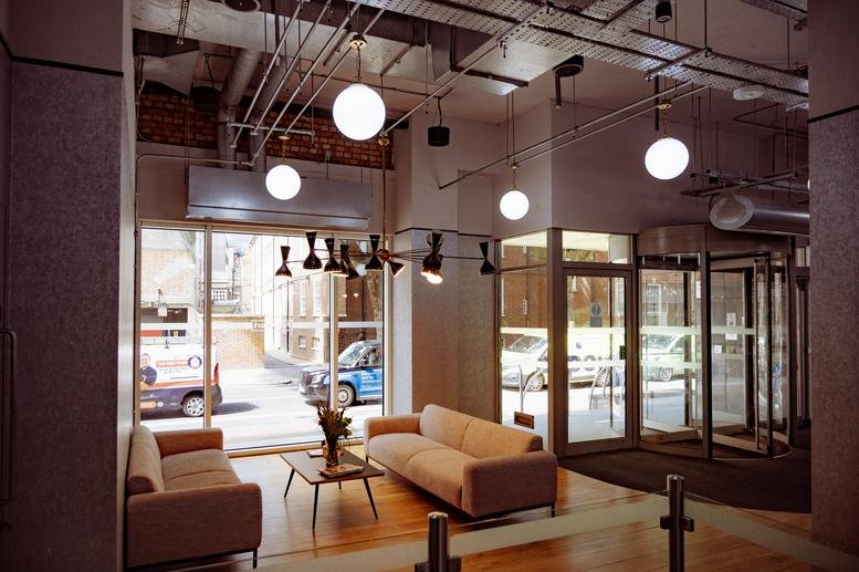 Building lobby at 14 Gray’s Inn Road with revolving doors, globe pendant lights, and soft seating.