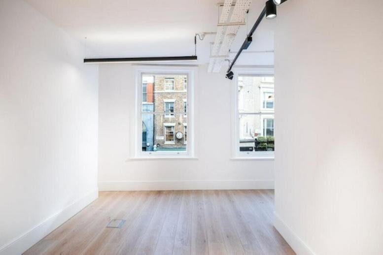 Bright, open-plan office space at 140 Shoreditch High Street with wooden floors and large windows.