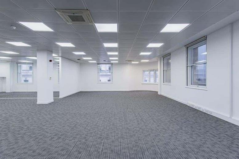 Large empty workspace featuring grey carpet and multiple windows.