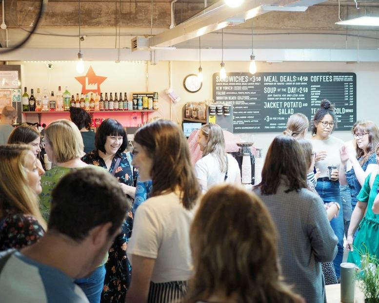 Lively communal break area and cafe at 15-17 Middle Street featuring a wooden bar and menu boards.
