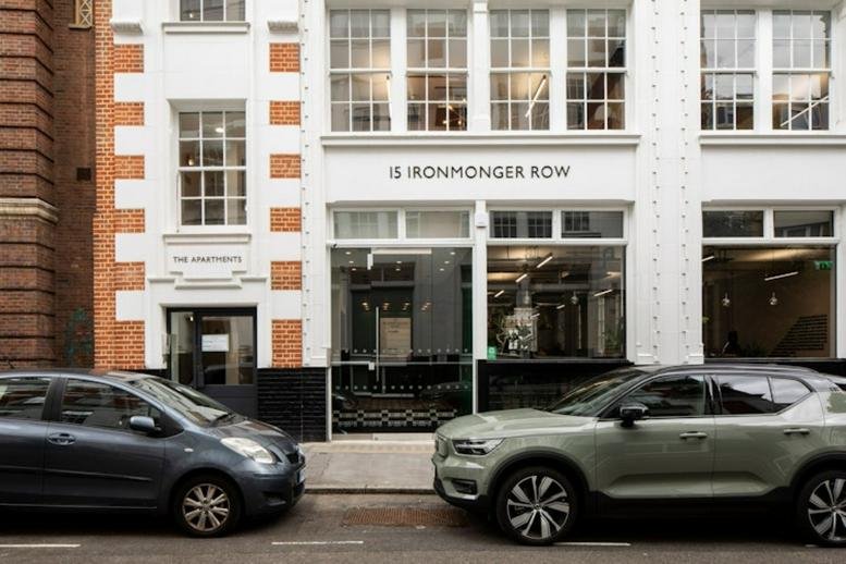 Exterior view of the white facade and entrance of 15 Ironmonger Row with parked cars in front.