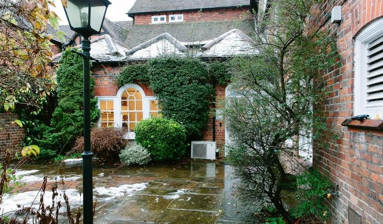 Exterior view of the brick facade and courtyard at 15 London End, Beaconsfield.
