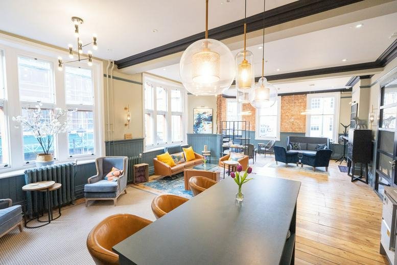 Spacious communal lounge at 150 Friar Street, Reading with eclectic seating and globe pendant lights.