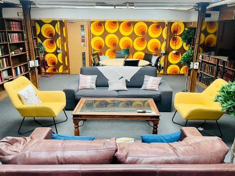 Colorful retro lounge at 157 London Road, Mitcham with patterned wallpaper and yellow armchairs.