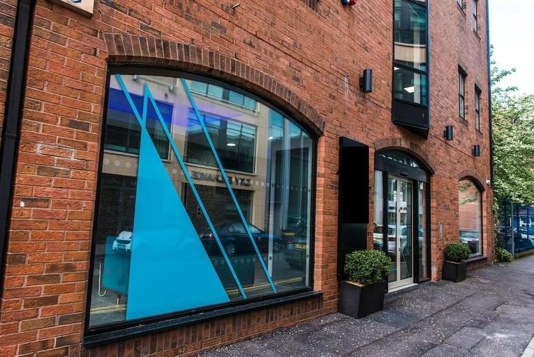 Exterior view of the brick facade and arched windows at 16-18 Gloucester Street, Northern Court, Belfast.