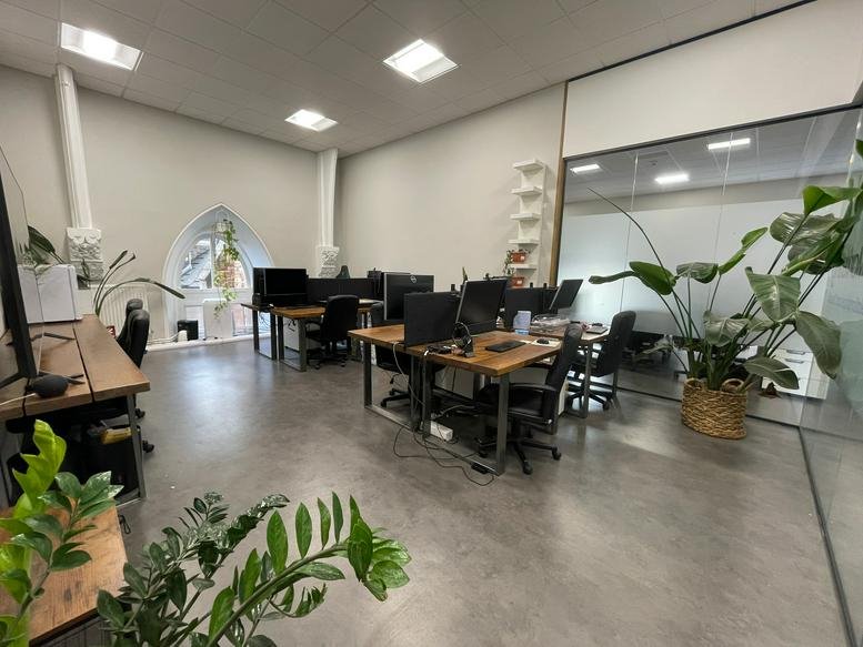 Spacious open-plan workspace at 16, Oakfield Road, Clifton, Bristol with wooden desks and indoor plants.