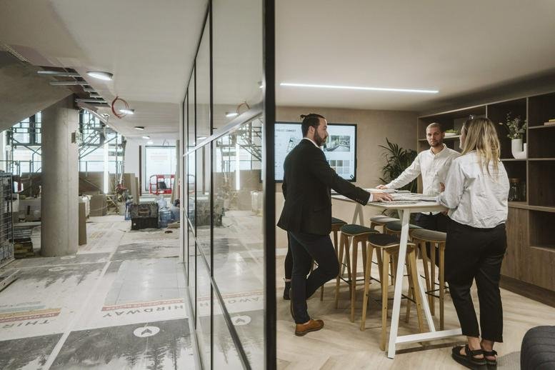 Spacious communal breakout area at 16 Tabernacle Street, London with wooden flooring and a standing meeting table.