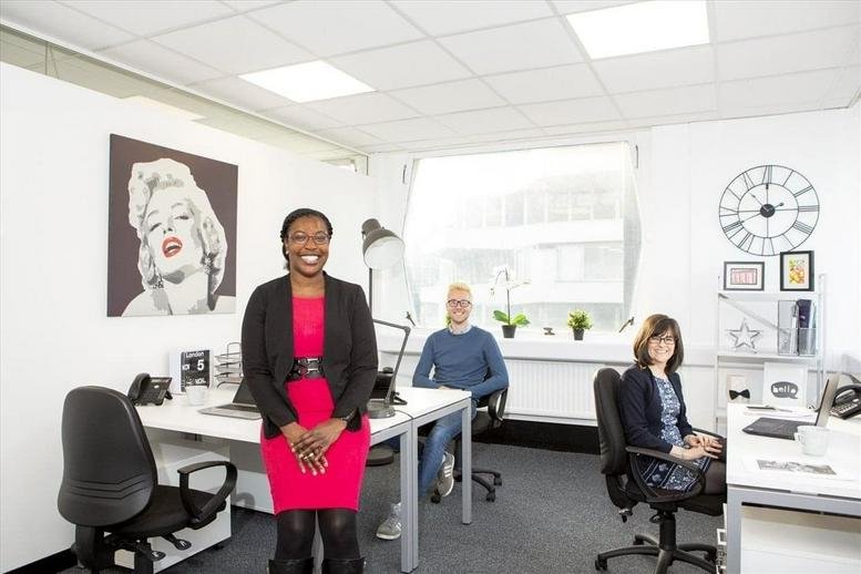 Spacious open-plan office at 168 Fulham Road with natural light, modern desks, and a portrait of Marilyn Monroe.