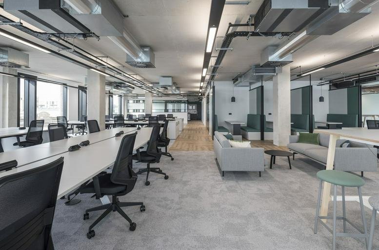 Open-plan workspace at 168 Shoreditch High St with rows of white desks and grey industrial ceilings.