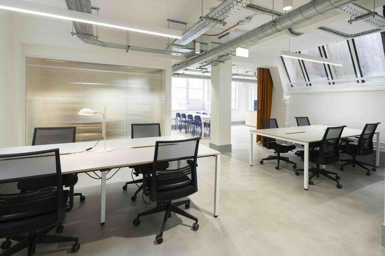 Bright open-plan workspace at 17 Aylesbury Street featuring white desks and black mesh chairs.