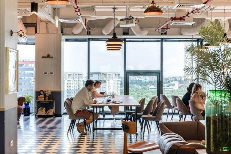 Spacious communal lounge at 17, Howard Road, Great Bookham, Surrey with floor-to-ceiling windows and city views.