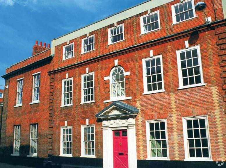 Exterior view of the red brick period building at 17 Palace Street, Norwich featuring a bright red door.
