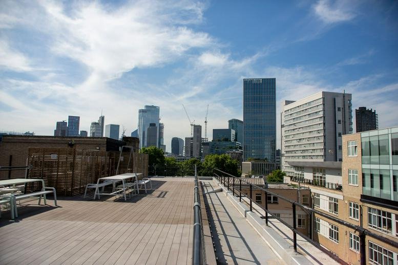 Spacious rooftop terrace at 174, 180 Silicon Roundabout, London with benches and panoramic city skyline views.