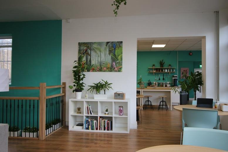 Spacious communal lounge at 17A Electric Lane with teal accent walls and white shelving.