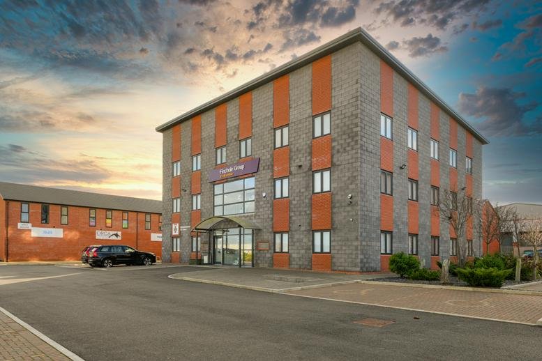 Exterior facade of the 18 Broomside Lane building under a dramatic sunset sky.