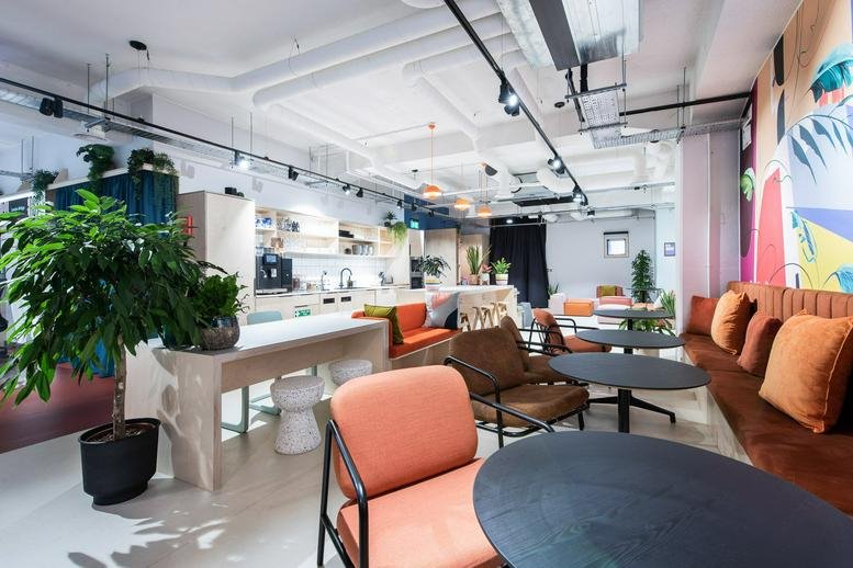 Lounge and breakout area with colorful furniture and greenery at 18 Crucifix Lane.