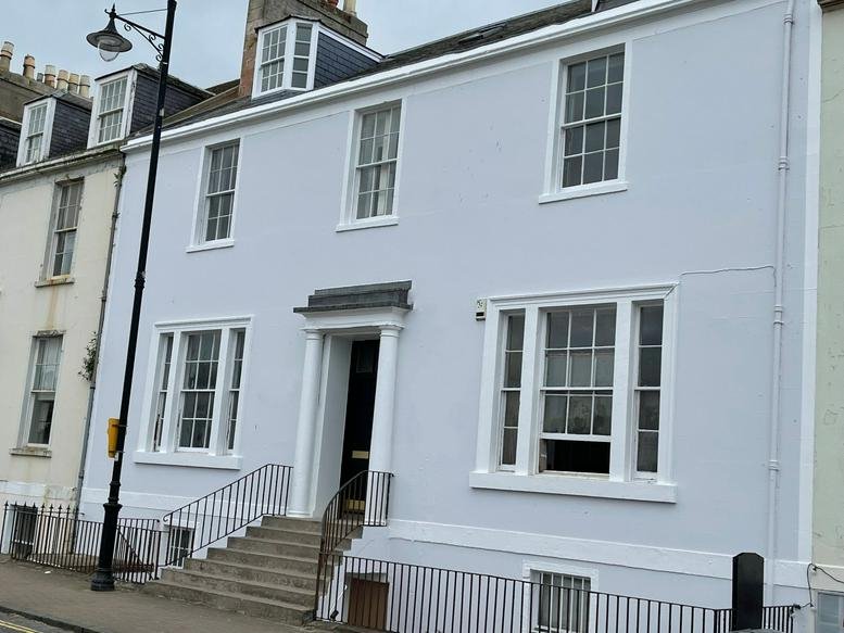 Exterior view of the light blue Georgian facade at 18 Wellington Square, Ayr, United Kingdom.
