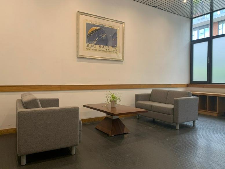 Spacious reception lounge at 180/182 Upper Richmond Road, London with grey sofas and wood coffee table.