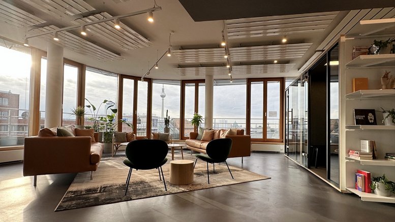 Spacious communal lounge with leather sofas, designer chairs, and floor-to-ceiling windows.