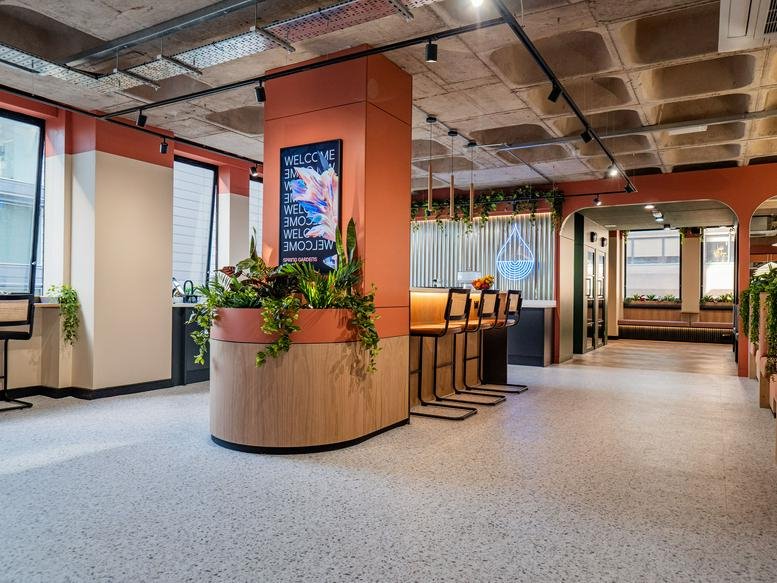 Reception and lounge area at 19, Spring Gardens, Manchester with terracotta pillars and indoor plants.