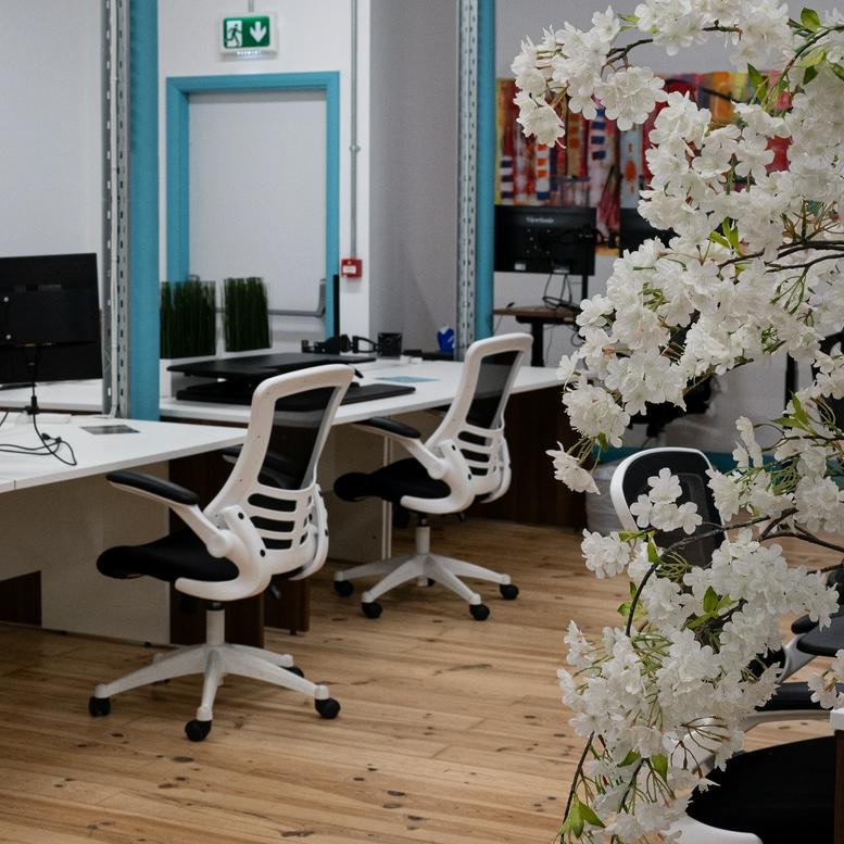 Spacious office interior at 2 Connell Street with white desks, ergonomic chairs, and floral decor.