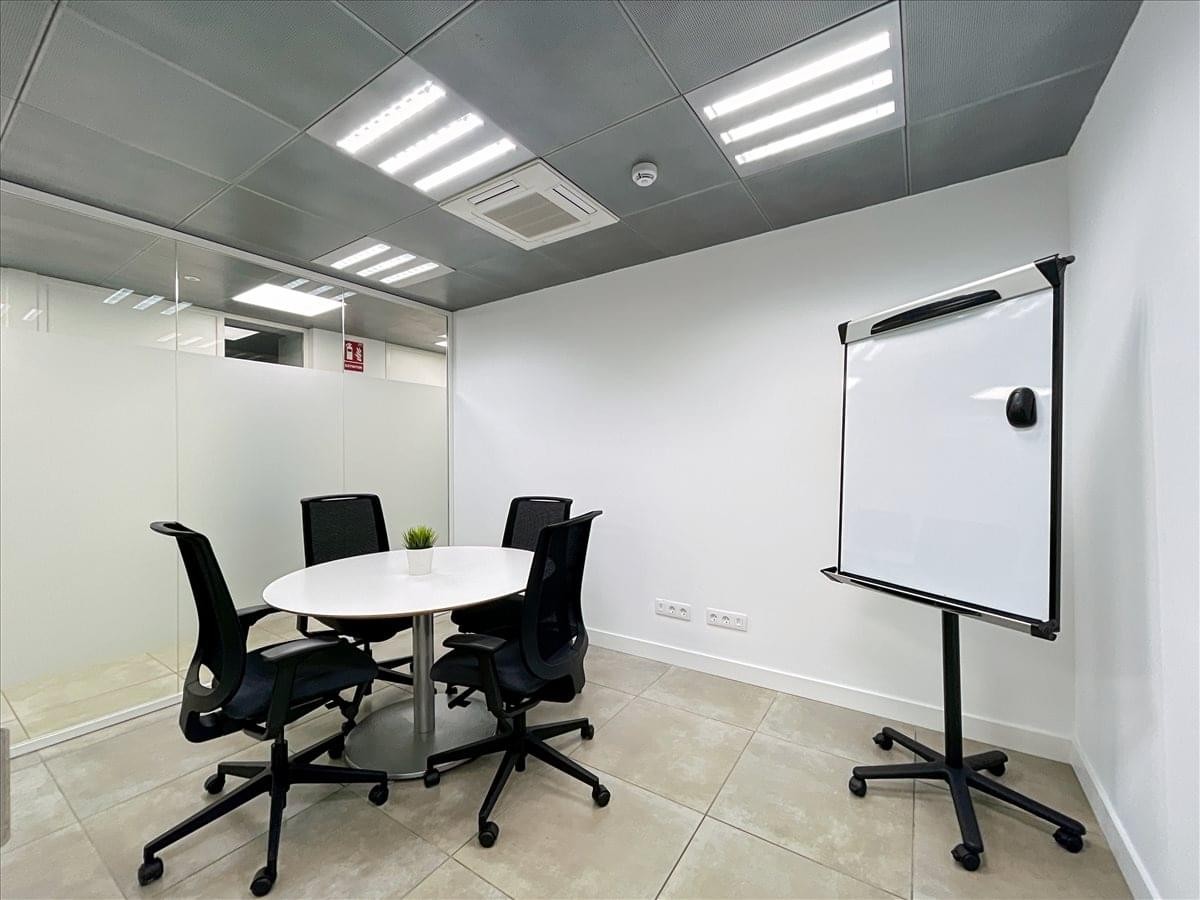 Modern reception area featuring a grey front desk and a white wall with company branding.
