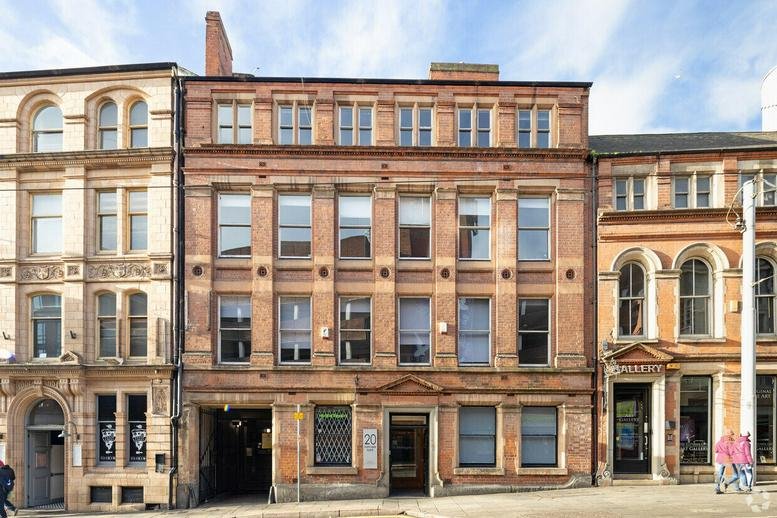 Exterior red brick facade of 20 Fletcher Gate, Nottingham with arched windows and stone detailing.