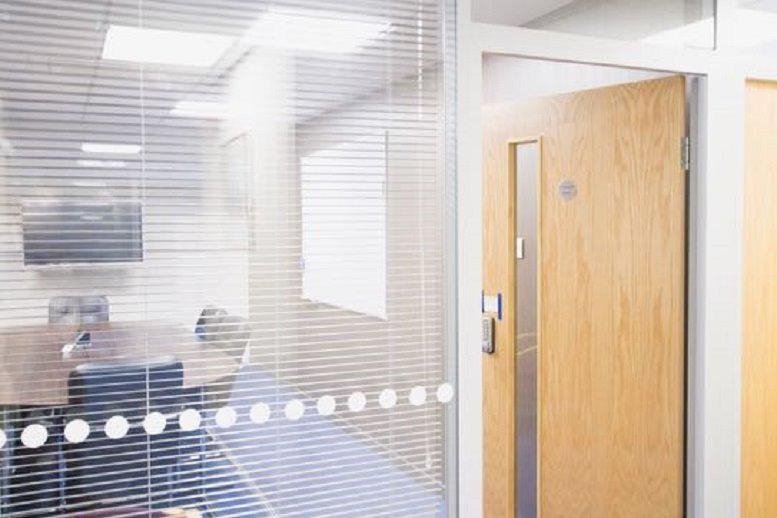 Meeting room at 20 Riverside, Riverside Industrial Estate seen through glass partition with blinds.