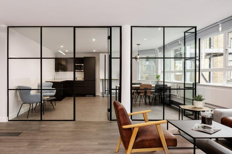 Lounge area with leather armchairs and glass partition walls.