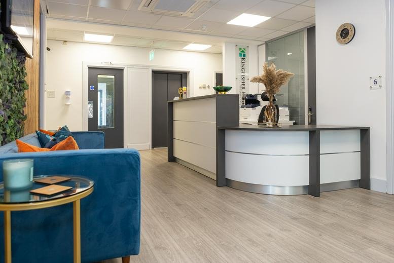 Modern reception area at 21 – 23 Elmfield Rd, Bromley with a blue sofa and white curved desk.