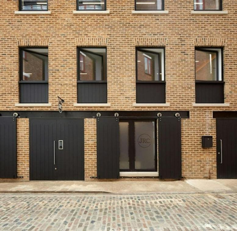 Exterior view of 21-23, Grafton Mews, London with brick facade and black features.