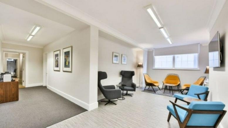 Bright reception and lounge area with colorful mid-century modern chairs and natural light.