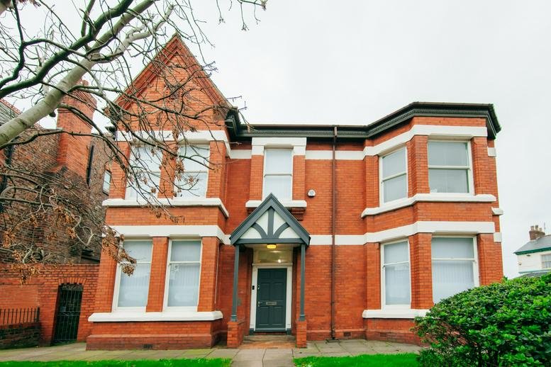 Exterior view of the red brick building facade at 21 Merton Road, Bootle.