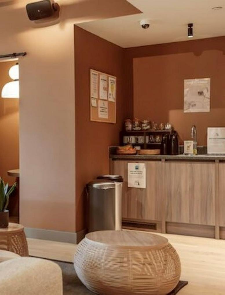 Warm breakout area at 21 Trewint Street with a wooden coffee table and refreshment station.