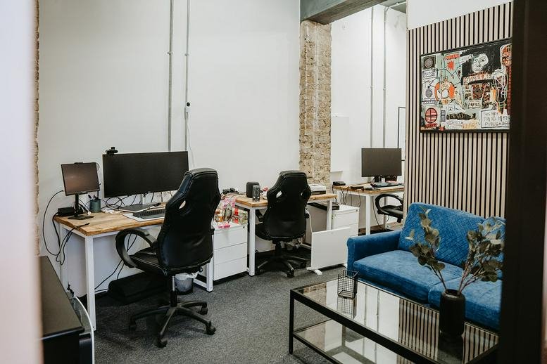 Spacious co-working area at 22-24 Elm Road with a blue velvet sofa and multiple workstations.