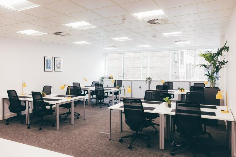 Spacious open-plan office at 220 St Vincent Street, Glasgow featuring white desks and black mesh chairs.
