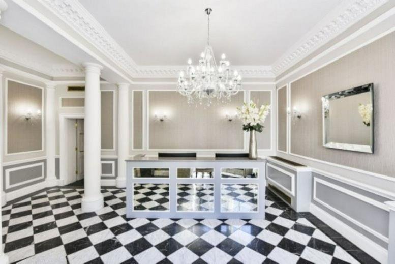 Sophisticated reception area with black and white checkered floor and crystal chandelier.