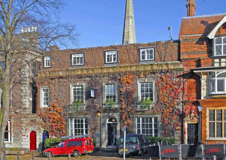 Exterior view of the historic ivy-covered building at 23, Tombland, Norwich, Norfolk.