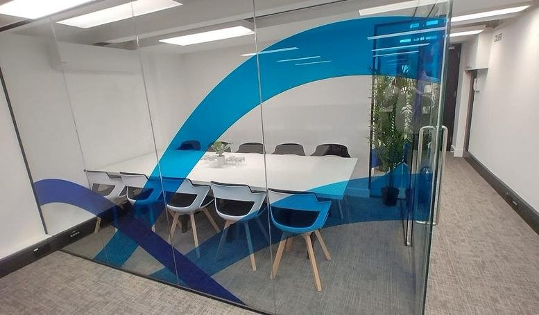 Enclosed meeting room at 25 Buckingham Palace Road with glass walls and blue wave graphics.