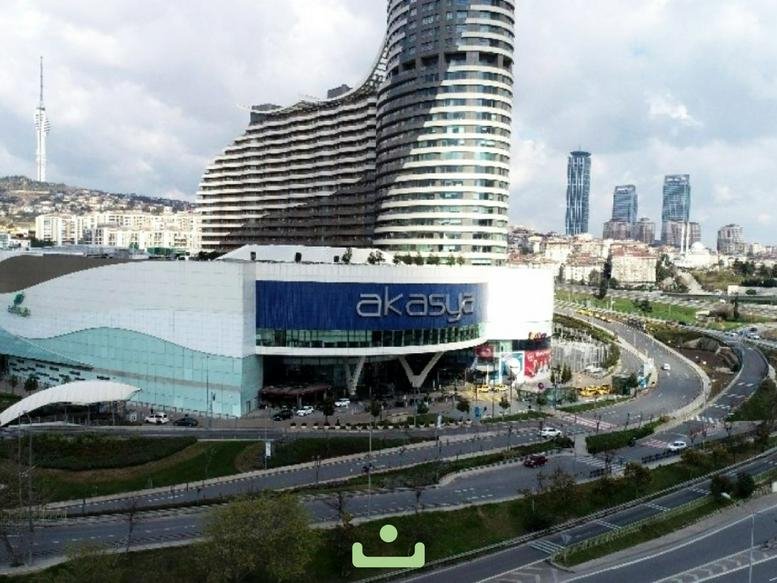 Exterior view of the modern Akasya building facade with a curved tower.