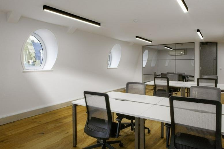 Spacious open-plan workspace at 25 Gerrard Street with arched windows and light wood floors.