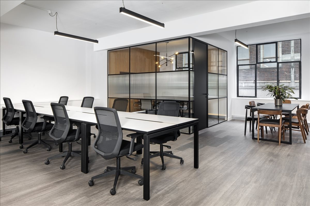 Spacious open-plan workspace at 25 Poland Street, Central London, W1F with modern desks and glass-walled meeting pod.