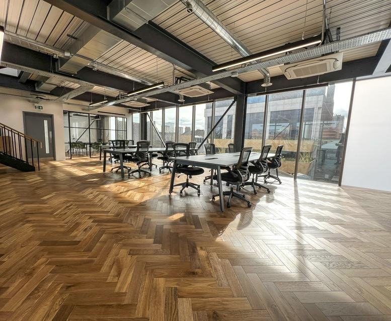 Spacious sunlit open-plan office with parquet floors and modern workstations at 25 Settles Street.
