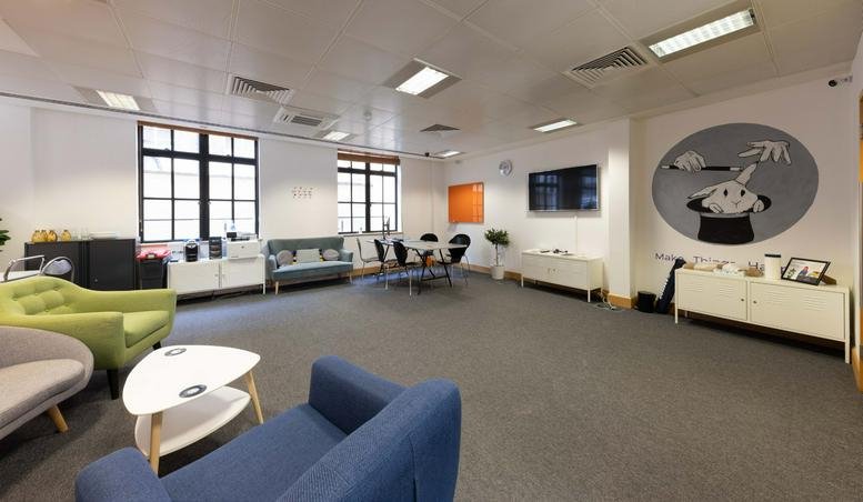 Spacious communal lounge with colorful seating and characterful wall art.