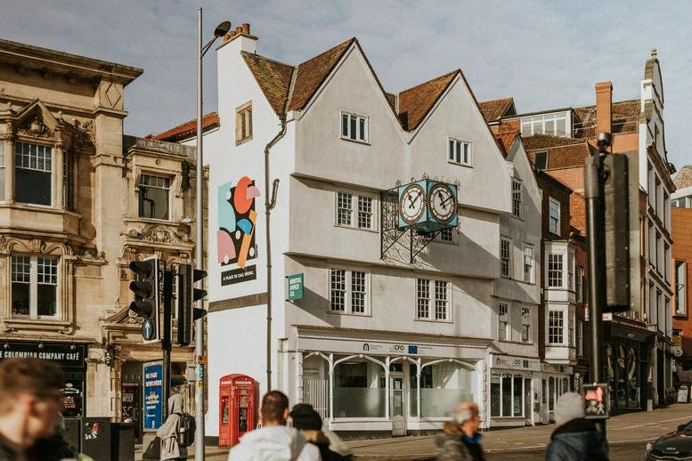 Exterior of 26-31 St Augustine’s Parade featuring white gabled facades and a prominent corner clock.