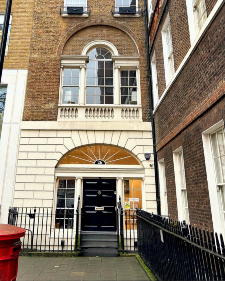 Grand Georgian exterior of 26, Soho Square, London featuring a distinctive arched window and black front door.